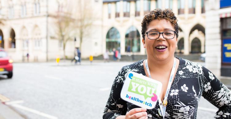 Healthwatch staff member holding an It Starts With You sign to promote the campaign