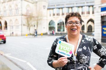 Healthwatch staff member holding an It Starts With You sign to promote the campaign