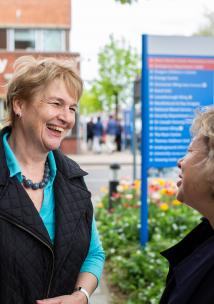 Two women speaking to one another outside a hospital